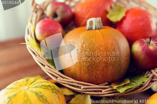 Image of close up of pumpkins in basket on wooden table