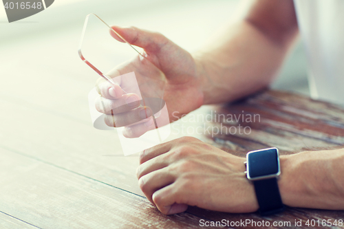 Image of close up of hands with smart phone and watch