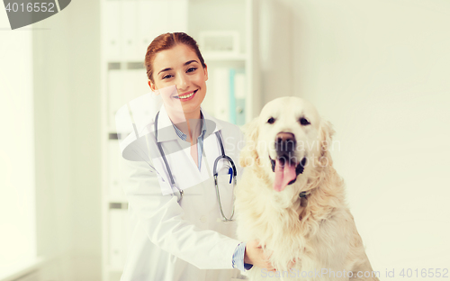 Image of happy doctor with retriever dog at vet clinic