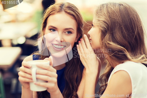 Image of young women drinking coffee and talking at cafe