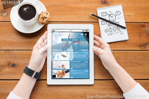 Image of close up of woman with tablet pc on wooden table