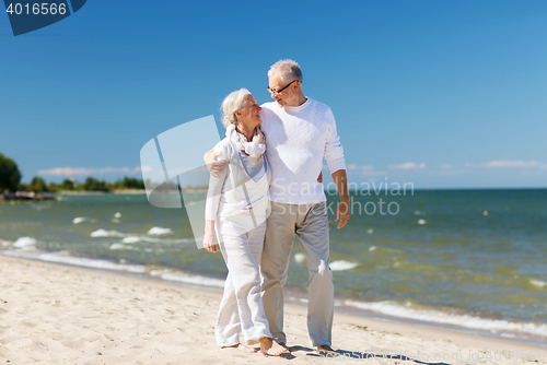 Image of happy senior couple hugging on summer beach