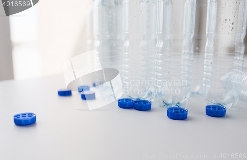 Image of close up of empty water bottles and caps on table