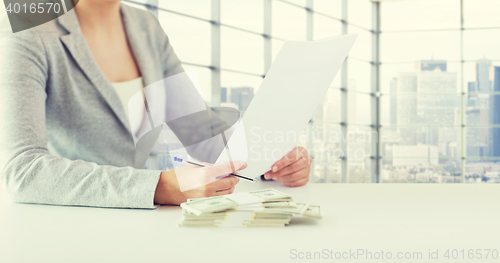 Image of close up of female hands with money and tax report