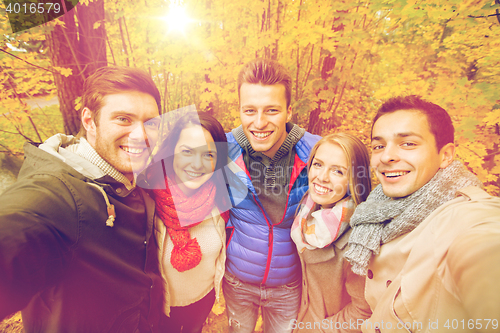Image of group of smiling men and women in autumn park
