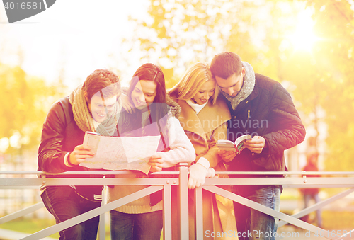 Image of couples with tourist map in autumn park