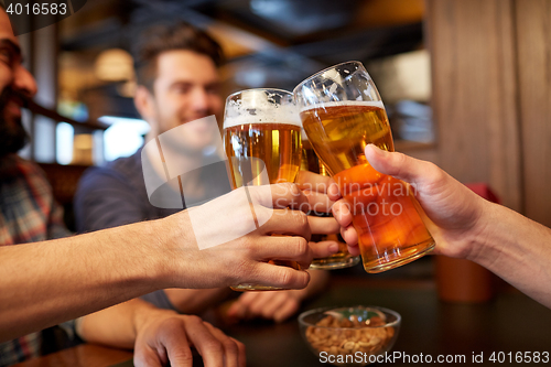 Image of happy male friends drinking beer at bar or pub