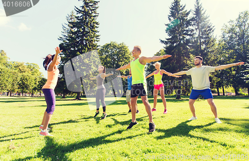 Image of group of happy friends exercising outdoors