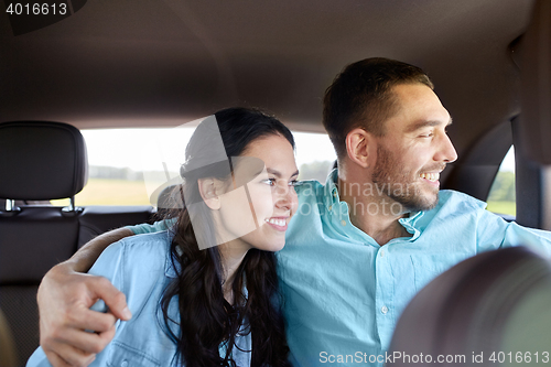 Image of happy man and woman hugging in car