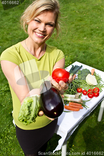 Image of Cute blond girl with vegetables