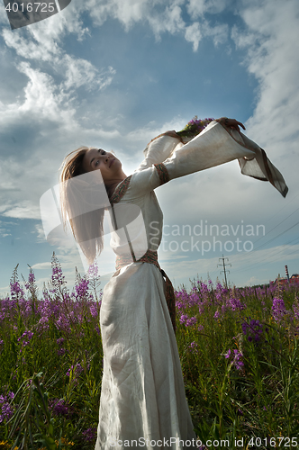 Image of Beautiful girl relaxing among flowers