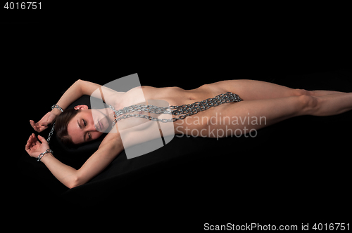 Image of Young sensual nude woman with chain over black