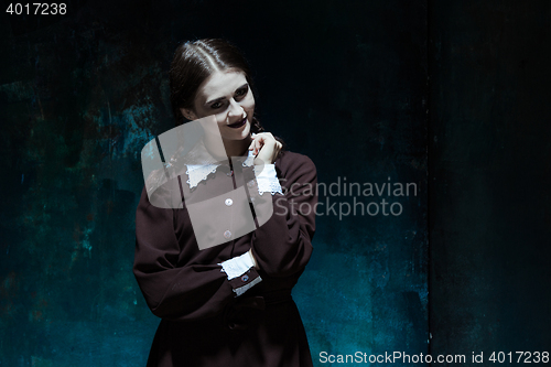 Image of Portrait of a young smiling girl in school uniform as killer woman