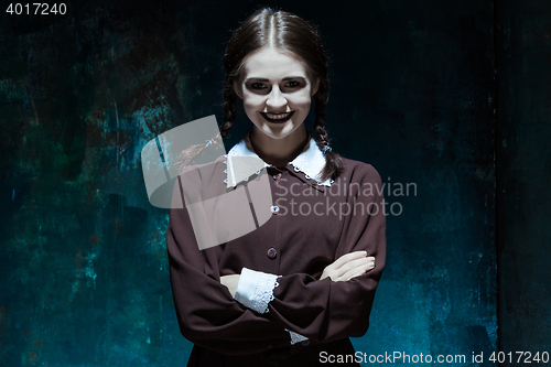 Image of Portrait of a young smiling girl in school uniform as killer woman