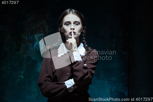 Image of Portrait of a young girl in school uniform as killer woman