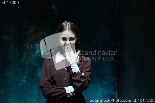 Image of Portrait of a young smiling girl in school uniform as killer woman