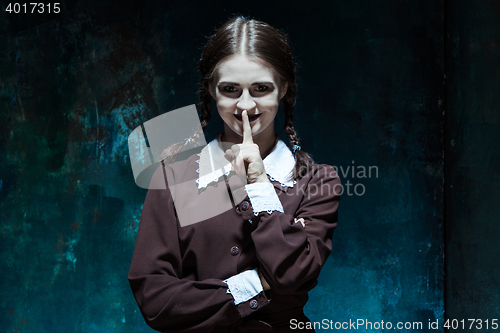 Image of Portrait of a young smiling girl in school uniform as killer woman