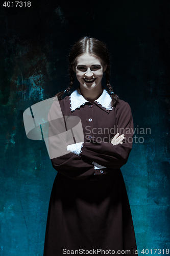 Image of Portrait of a young smiling girl in school uniform as killer woman