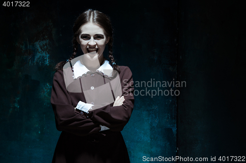 Image of Portrait of a young smiling girl in school uniform as killer woman