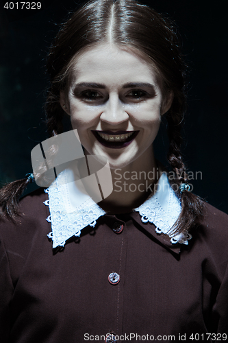 Image of Portrait of a young smiling girl in school uniform as killer woman