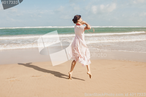 Image of Woman walking on the beach sand