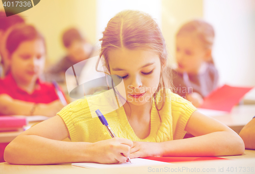 Image of group of school kids writing test in classroom