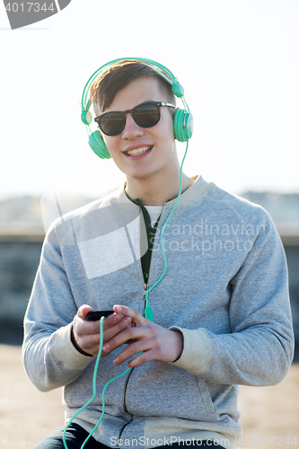 Image of happy young man in headphones with smartphone