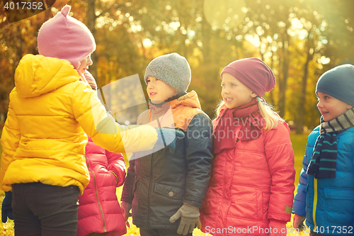 Image of kids in autumn park counting and choosing leader