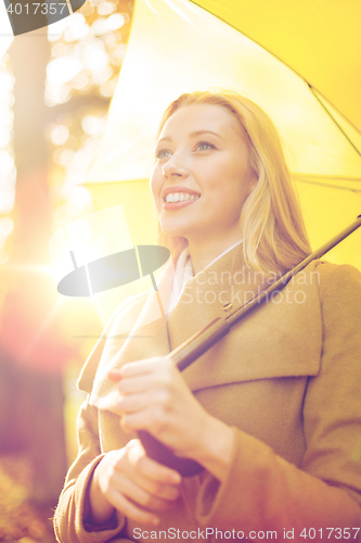 Image of woman with yellow umbrella in the autumn park