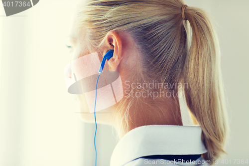 Image of close up of woman in earphones at home