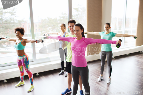 Image of group of smiling people working out with dumbbells