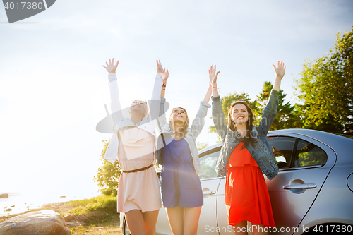 Image of happy teenage girls or women near car at seaside