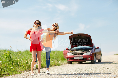 Image of women with broken car hitchhiking at countryside