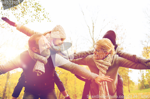 Image of happy family having fun in autumn park