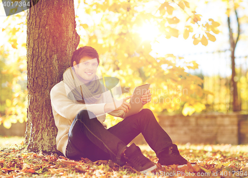 Image of man with tablet pc in autumn park