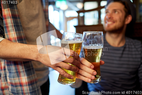 Image of happy male friends drinking beer at bar or pub