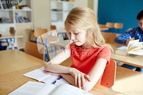 Image of student girl with book at school lesson
