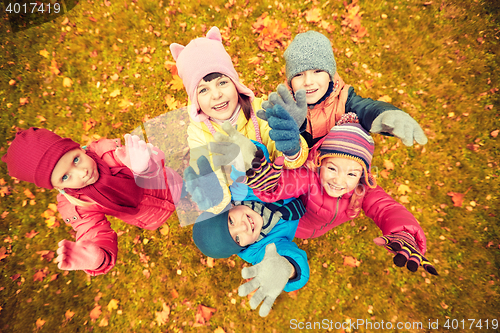 Image of happy children waving hands in autumn park
