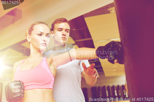 Image of woman with personal trainer boxing in gym