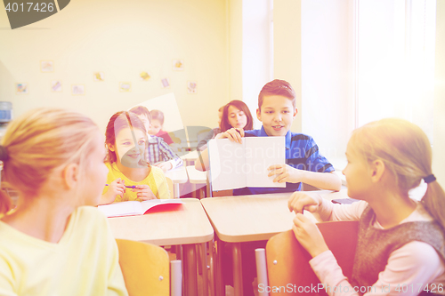 Image of group of school kids writing test in classroom