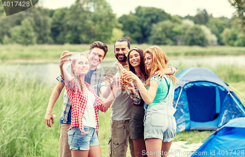 Image of happy friends taking selfie by smartphone at camp