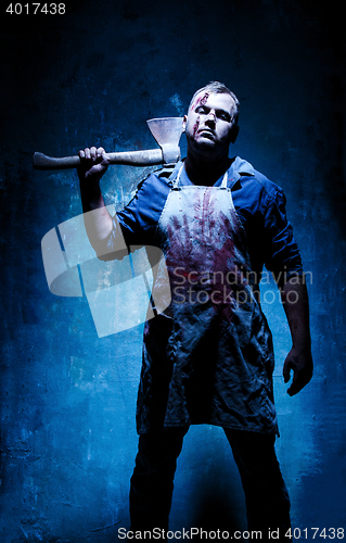 Image of Bloody Halloween theme: crazy killer as bloody butcher with an ax