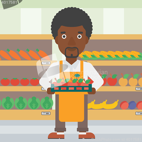 Image of Supermarket worker with box full of apples.