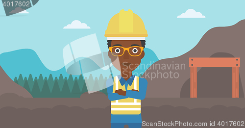 Image of Miner with mining equipment on background.