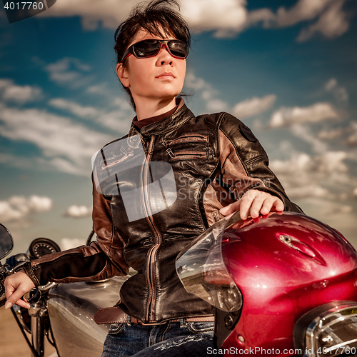 Image of Biker girl sitting on motorcycle