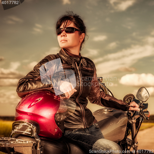 Image of Biker girl sitting on motorcycle