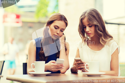 Image of women with smartphones and coffee at outdoor cafe