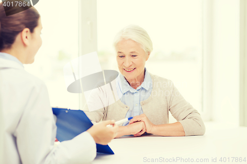 Image of doctor with clipboard and senior woman at hospital