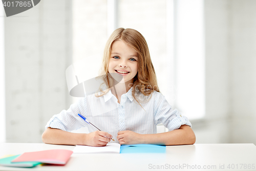 Image of happy smiling school girl with notebook and pen