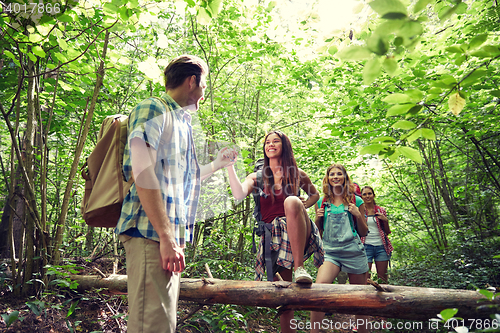 Image of group of smiling friends with backpacks hiking